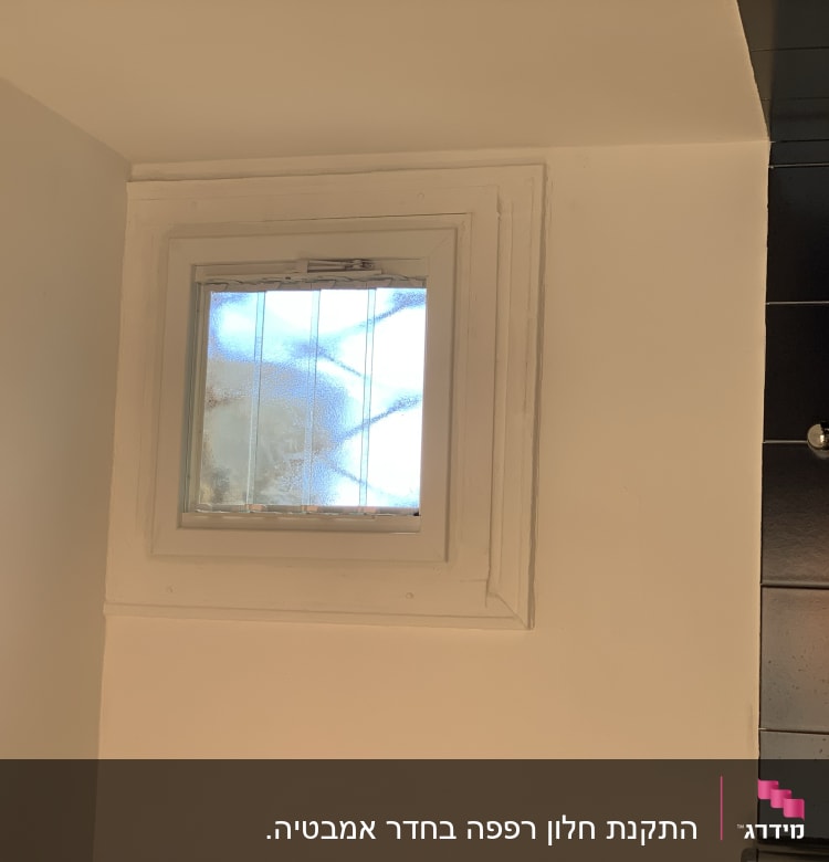 חלון קטן עם זכוכית חלבית ומסגרת לבנה